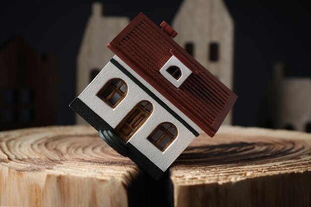 Modelo de casa em toco de madeira rachado representando closeup de desastre de terremoto