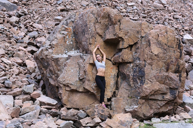 modelo de menina no fundo de uma grande pedra