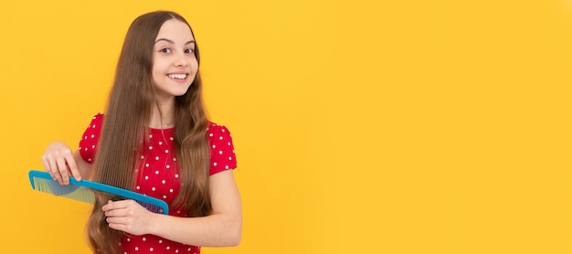 Modelo de moda feminina criança feliz penteando cabelos longos cabeleireira tem penteado ondulado Garoto cuidados com o cabelo