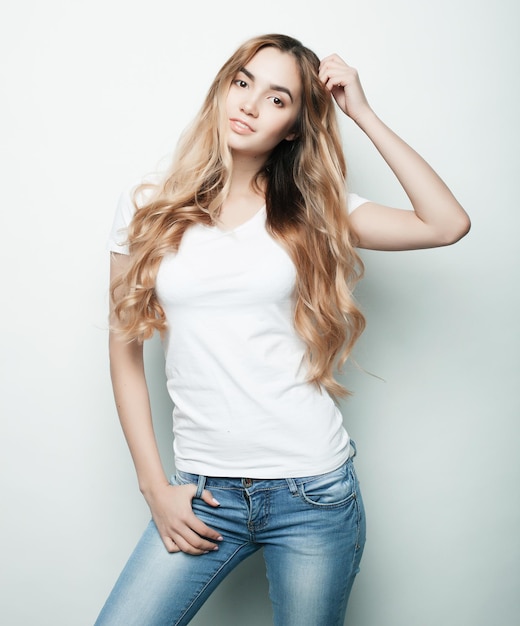 Modelo de moda jovem posando em fundo de estúdio branco