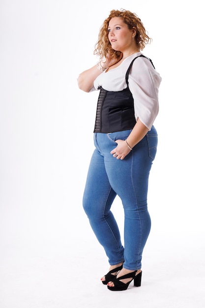 Modelo de moda plus size mulher gorda em roupas jeans e camisa branca sobre fundo branco corpo feminino com sobrepeso