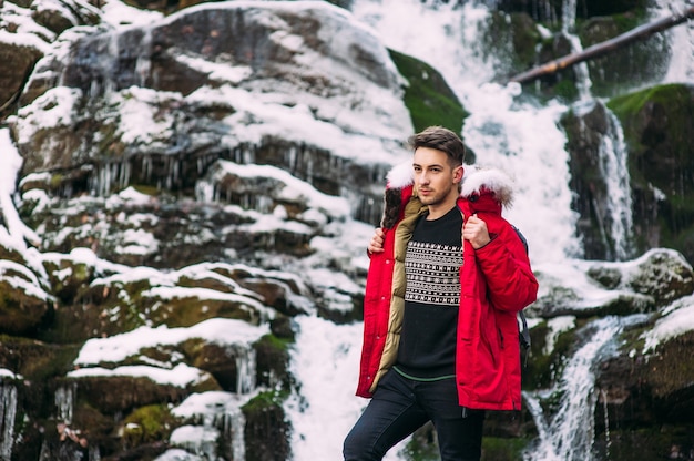 Modelo de modelo NICE posando perto da cachoeira nas montanhas de inverno