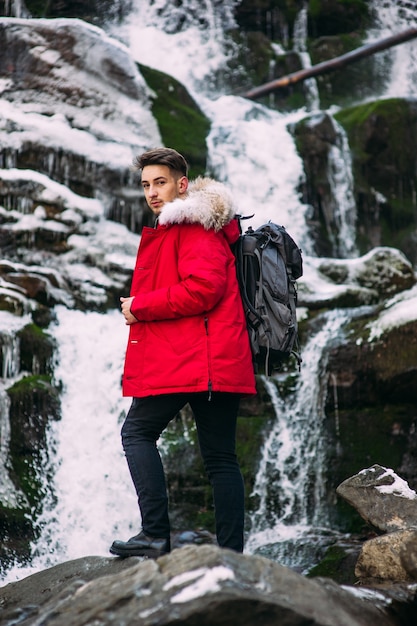 Modelo de modelo NICE posando perto da cachoeira nas montanhas de inverno