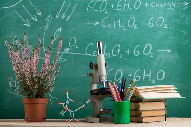 Modelo de molécula de livros de conceito de educação e ciências e microscópio na mesa no fundo do quadro de auditório