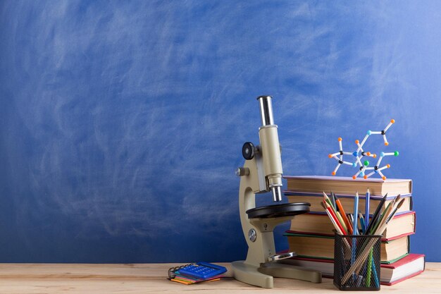 Modelo de molécula de livros de conceito de educação e ciências e microscópio na mesa no fundo do quadro de auditório