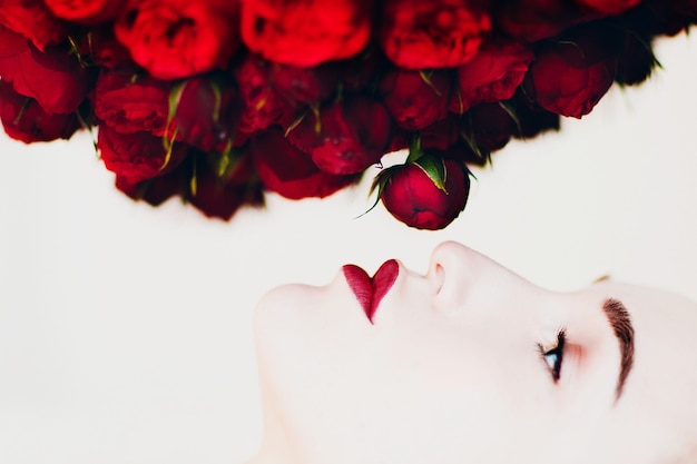 Modelo de mulher bonita cheirando flores buguet de rosas em forma de píon
