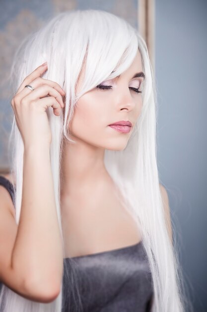 Modelo de mulher bonita com cabelo longo branco platinado no fundo do interior