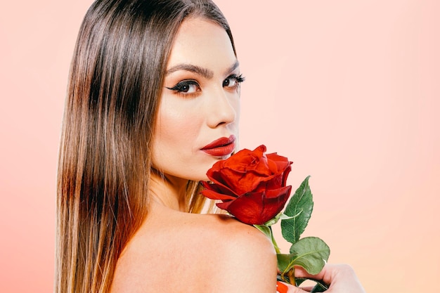 Modelo de mulher bonita segurando uma rosa vermelha