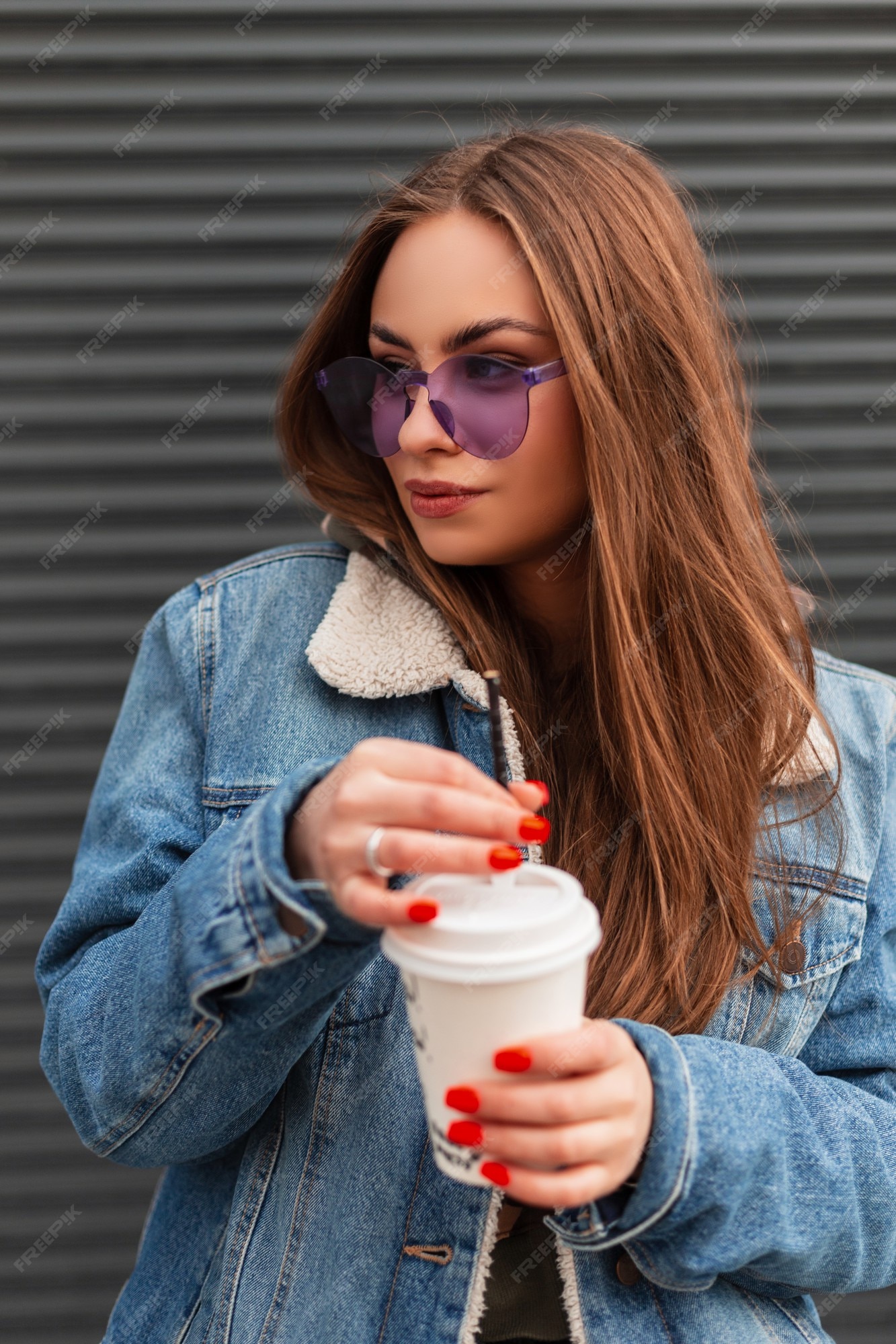 Mulher bonita e jovem hippie em uma jaqueta jeans da moda com uma