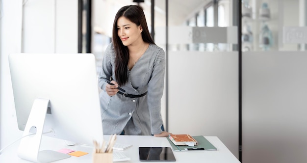 Modelo de negócios comercial bonito mulher corporativa morena sorrindo e trabalhando no escritório