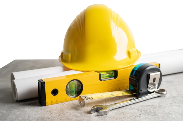 Modelo de projeto de planta de casa arquitetônica e capacete amarelo com ferramentas de construção de engenheiro de calculadora