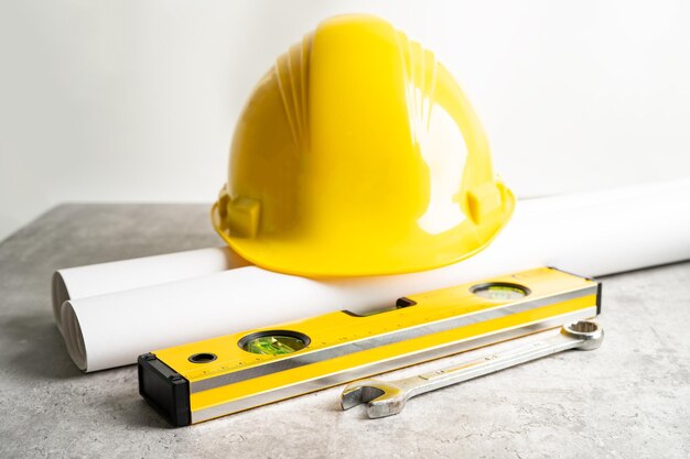 Modelo de projeto de planta de casa arquitetônica e capacete amarelo com ferramentas de construção de engenheiro de calculadora