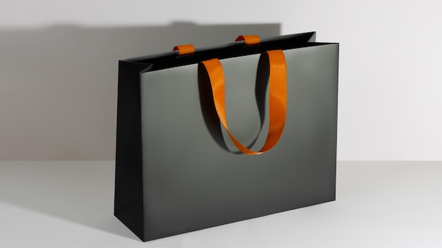 Modelo de saco de compras brilhante de papel preto com alças laranja
