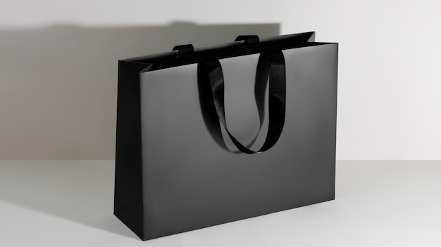 Modelo de saco de compras brilhante de papel preto com alças pretas