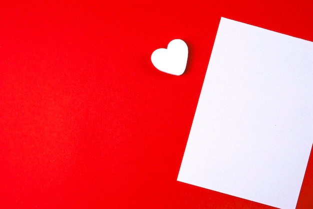 Modelo de simulação de carta de amor Esvazie o papel branco em branco sobre fundo de papel vermelho e um coração branco