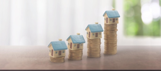 Modelo de simulação de casa em miniatura destacada e conceito de investimento imobiliário de propriedade de moedas