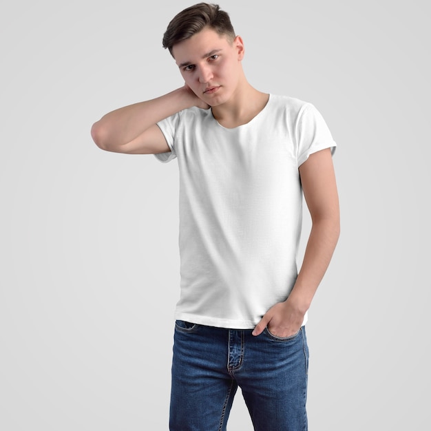 Modelo de t-shirt dos homens brancos em um jovem em um plano de fundo no estúdio. roupa de maquete para apresentação de design e publicidade na loja online. vista frontal.