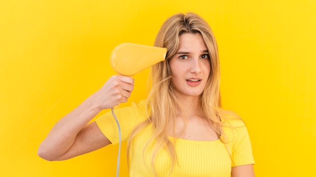 Modelo de tiro médio, segurando o secador de cabelo