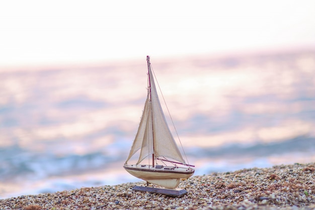 Foto modelo de um navio de madeira no fundo de uma costa natural do mar