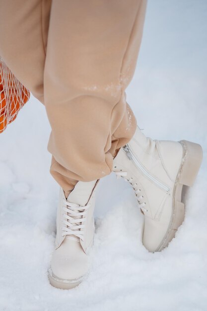 El modelo demuestra los zapatos de mujer de pie en la nieve.