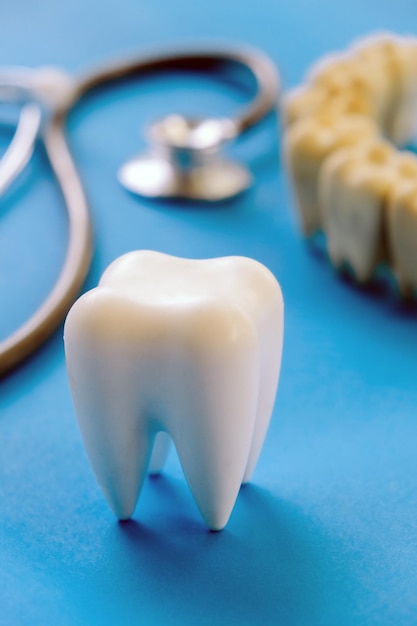 Modelo dentário e equipamento dentário em fundo azul imagem conceitual de fundo dentário