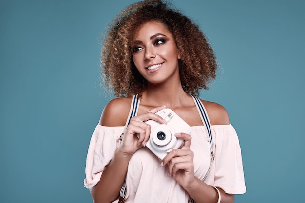 Modelo elegante mulher negra com cabelo encaracolado e câmera