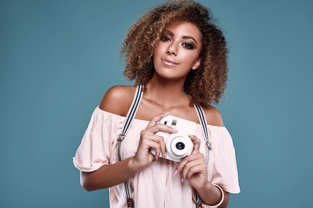 Modelo elegante mulher negra com cabelo encaracolado e câmera