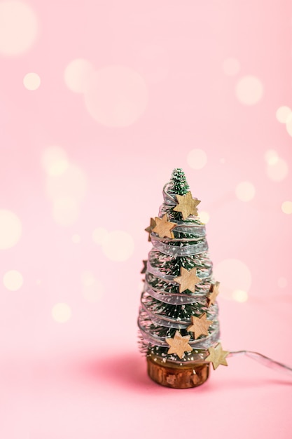 Modelo em miniatura winter pine tree com neve. composição minimalista em um rosa.