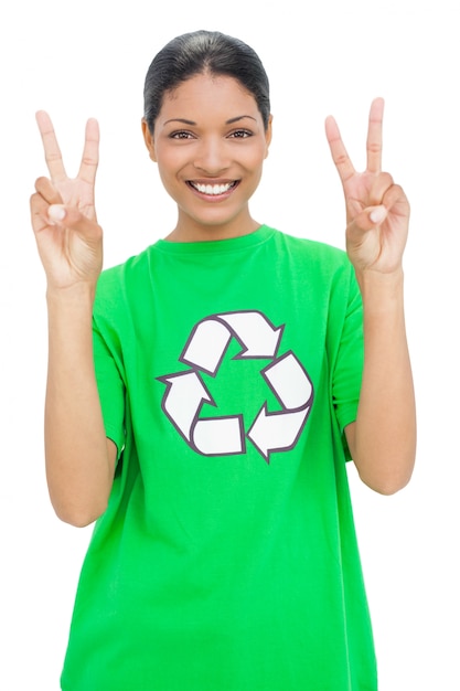 Modelo feliz que lleva la camiseta del reciclaje que hace gesto pacífico