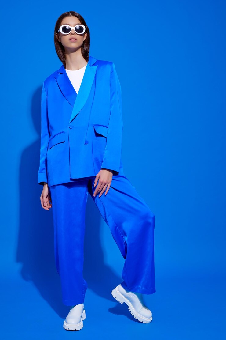 Foto modelo femenino asiático de moda con traje azul botas blancas y gafas de sol