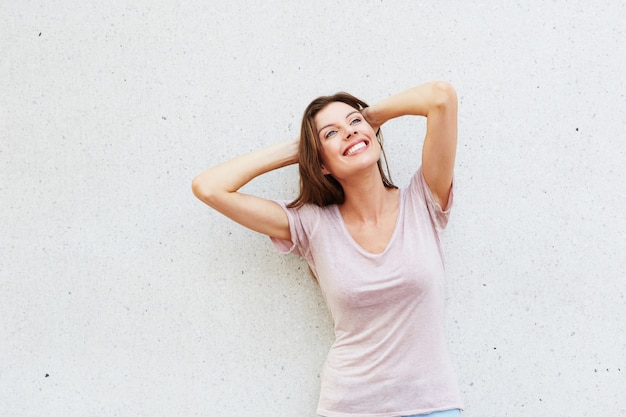 Foto modelo femenino atractivo posando contra la pared blanca