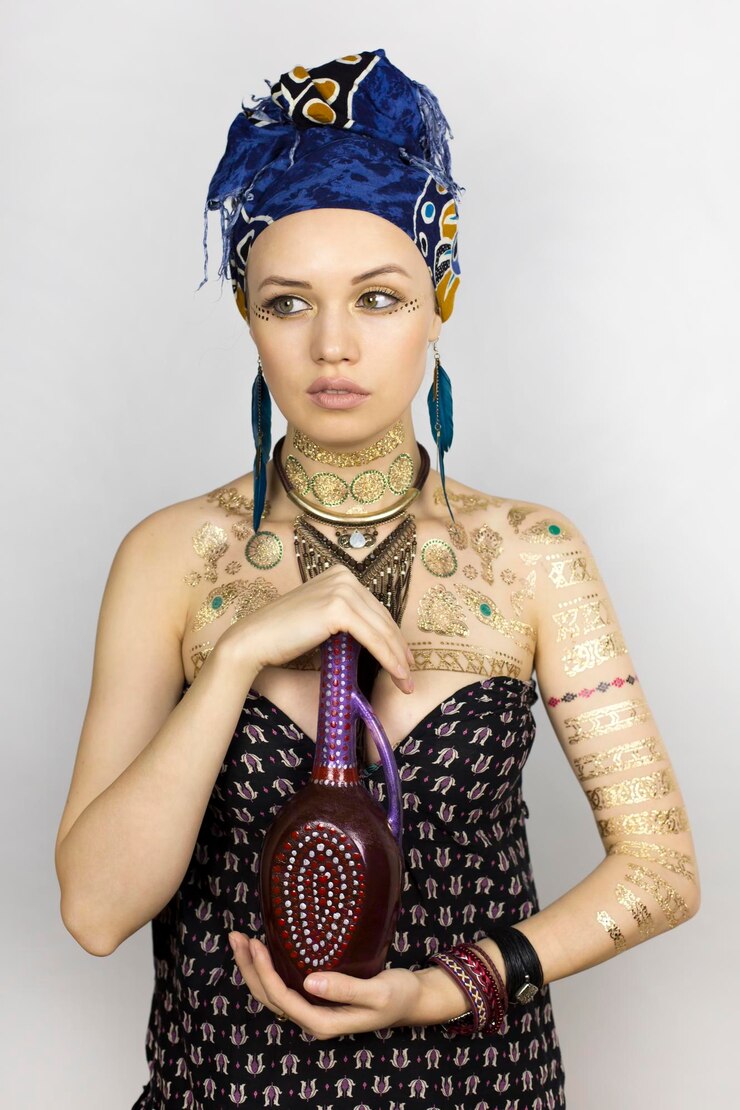 Foto modelo femenino joven pensativo sosteniendo una botella mientras está de pie contra un fondo blanco
