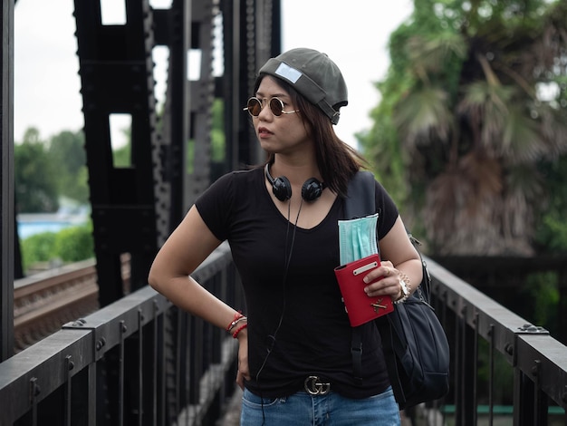 Modelo femenino usar sombrero gafas de sol mochila maleta pasaporte máscara viaje aventura viaje viaje turismo viaje nueva normalidad covid19 delta omicron fly terminal en todo el mundo temporada de verano global