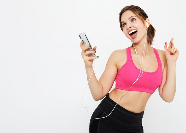 Modelo femenino viste ropa deportiva escucha música favorita