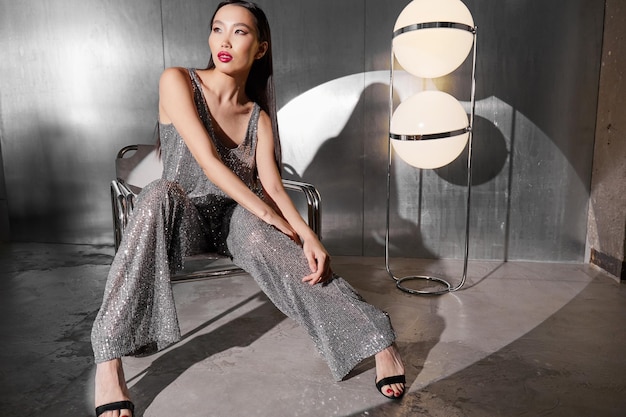 Foto modelo feminino asiático de moda em terno de brilho de prata metálico