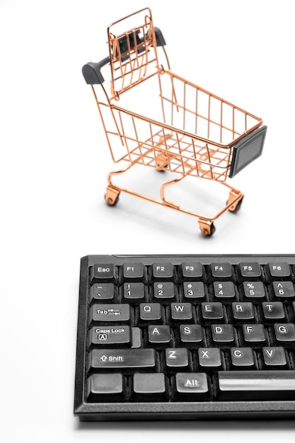 Foto modelo de figura de carrito de compras y teclado de computadora aislado sobre fondo blanco concepto de black friday y cyber monday