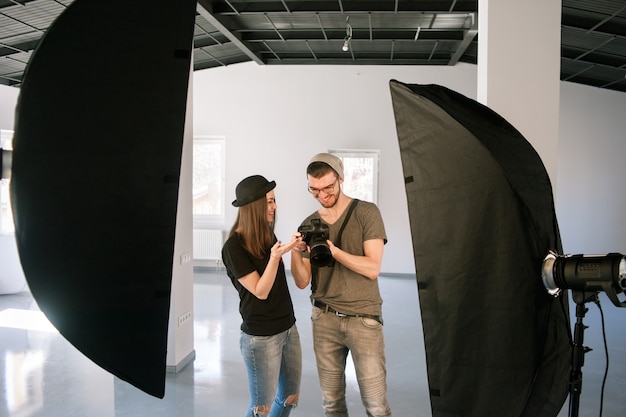 La modelo y el fotógrafo disfrutan de las fotos en la cámara