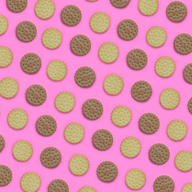 Modelo de galletas marrones en un fondo rosado. Concepto minimalista de moda de comida y postre.