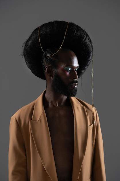 Modelo gay afro-americano sério com peruca enorme sobre fundo preto