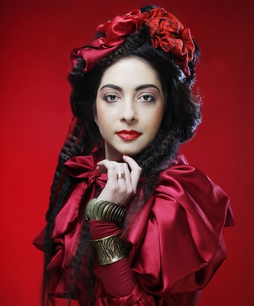 Foto modelo de glamour en traje rojo de elegancia con sombrero rojo. tiro del estudio.