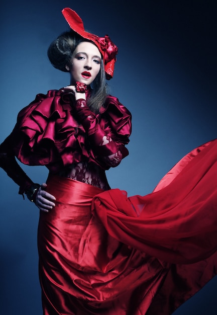 Modelo de glamour en traje rojo elegancia con sombrero rojo