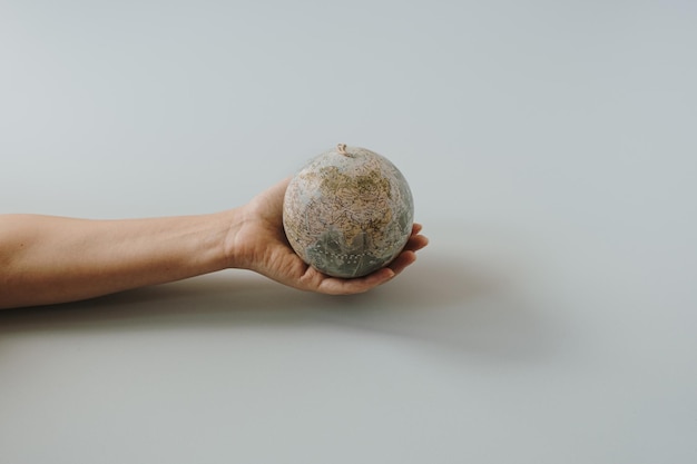 Modelo de globo en mano femenina sobre fondo azul Salvar el mundo planeta Tierra concepto Derechos de la mujer y concepto de poder