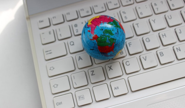 Modelo del globo terrestre en el teclado de la computadora con caracteres latinos sólo vista superior