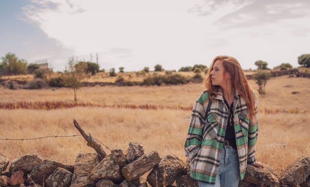 Una modelo guapa posa con un campo en su fondo