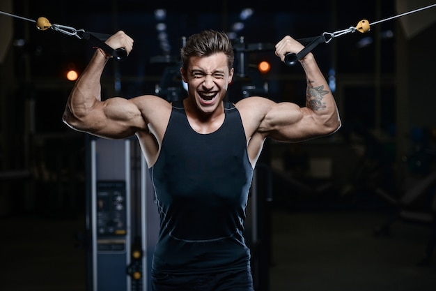 Modelo guapo joven entrenamiento en gimnasio