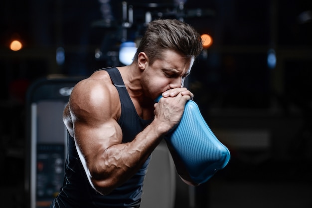 Modelo guapo joven entrenamiento en gimnasio