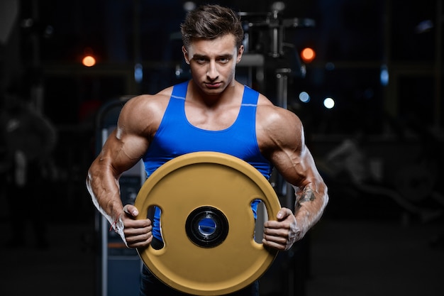 Modelo guapo joven entrenamiento en gimnasio