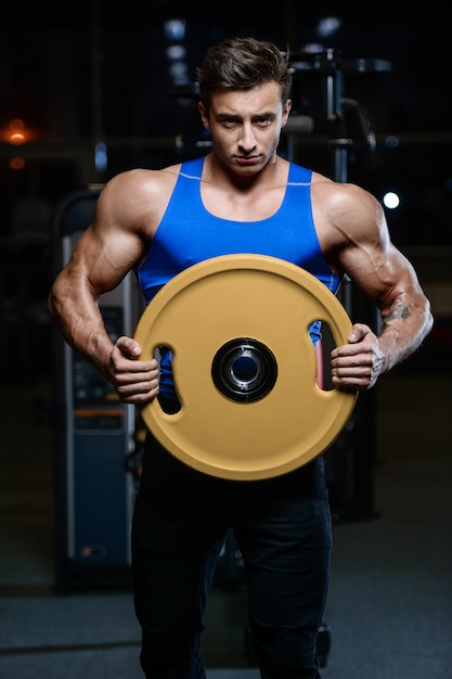 Modelo guapo joven entrenamiento en gimnasio