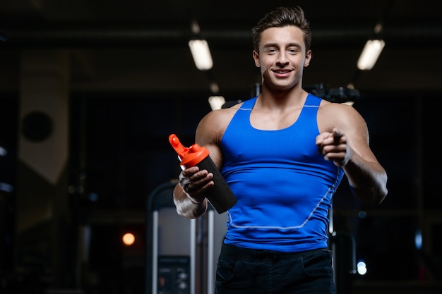 Modelo guapo joven entrenamiento en gimnasio