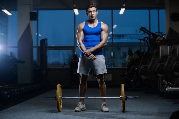 Modelo guapo joven entrenamiento en gimnasio